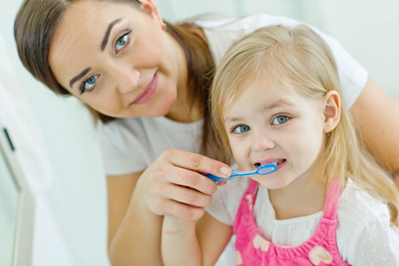 Mom and Daughter brushing their teeth - Pediatric Dentist in Gulfport, MS